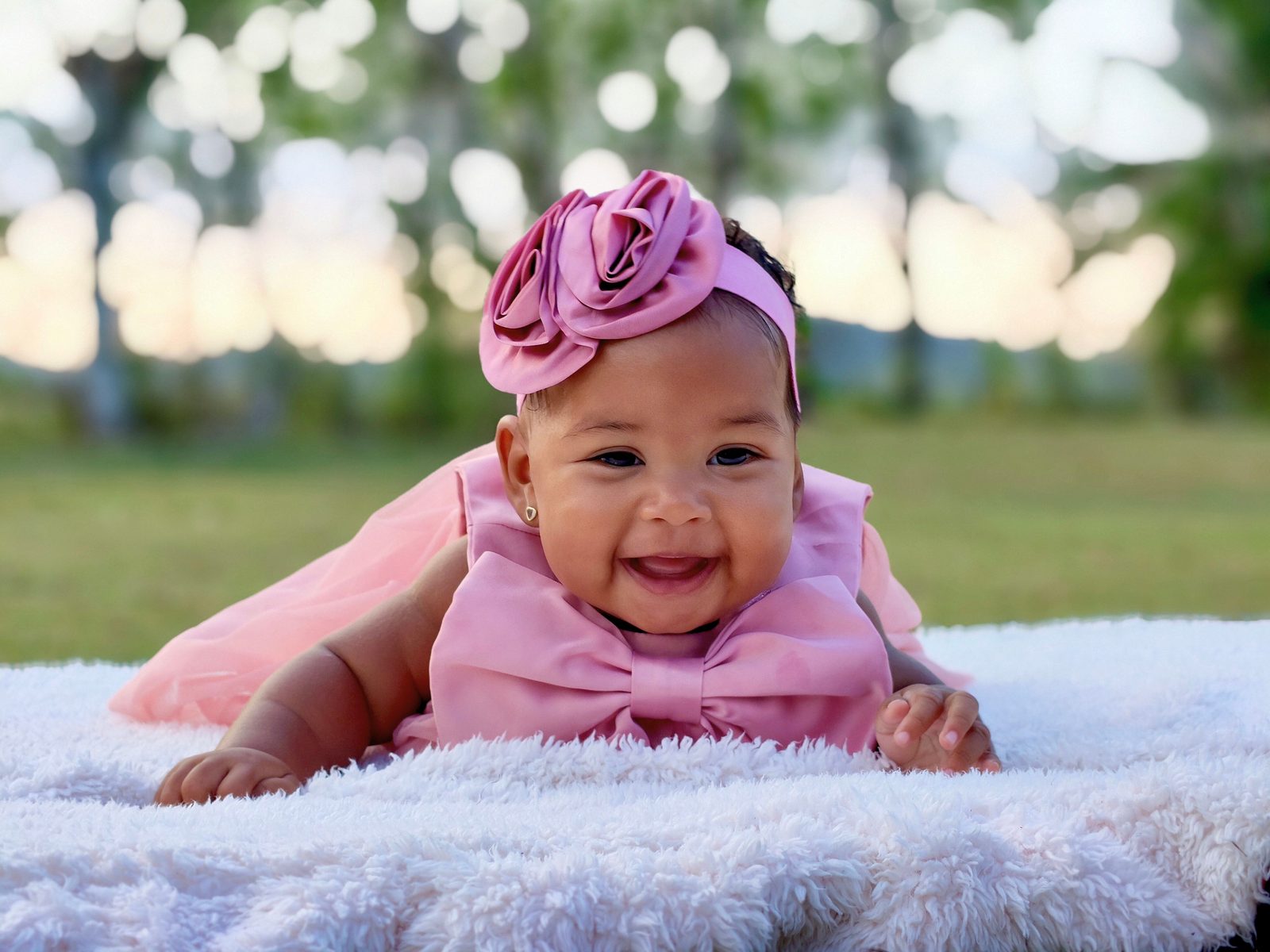 A child laughing outdoors in the summer.